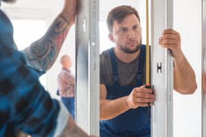 Young builder measuring the frame in renovated house